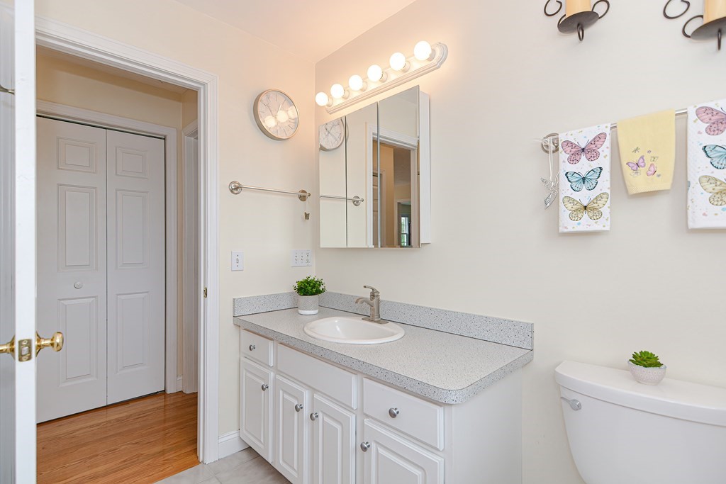 237 Pleasant Street, Unit 237 Norwood, MA 02062 - Photo 21 of 40 a bathroom with a sink a toilet and a mirror