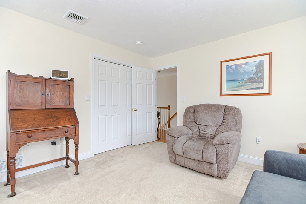 237 Pleasant Street, Unit 237 Norwood, MA 02062 - Photo 22 of 40 a living room with furniture and a refrigerator