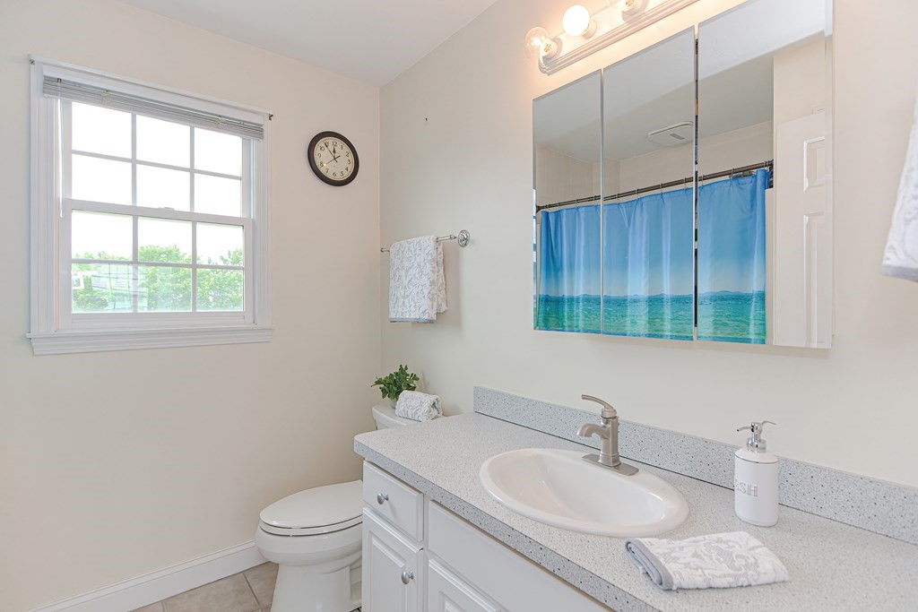 237 Pleasant Street, Unit 237 Norwood, MA 02062 - Photo 29 of 40 a bathroom with a granite countertop sink and a toilet