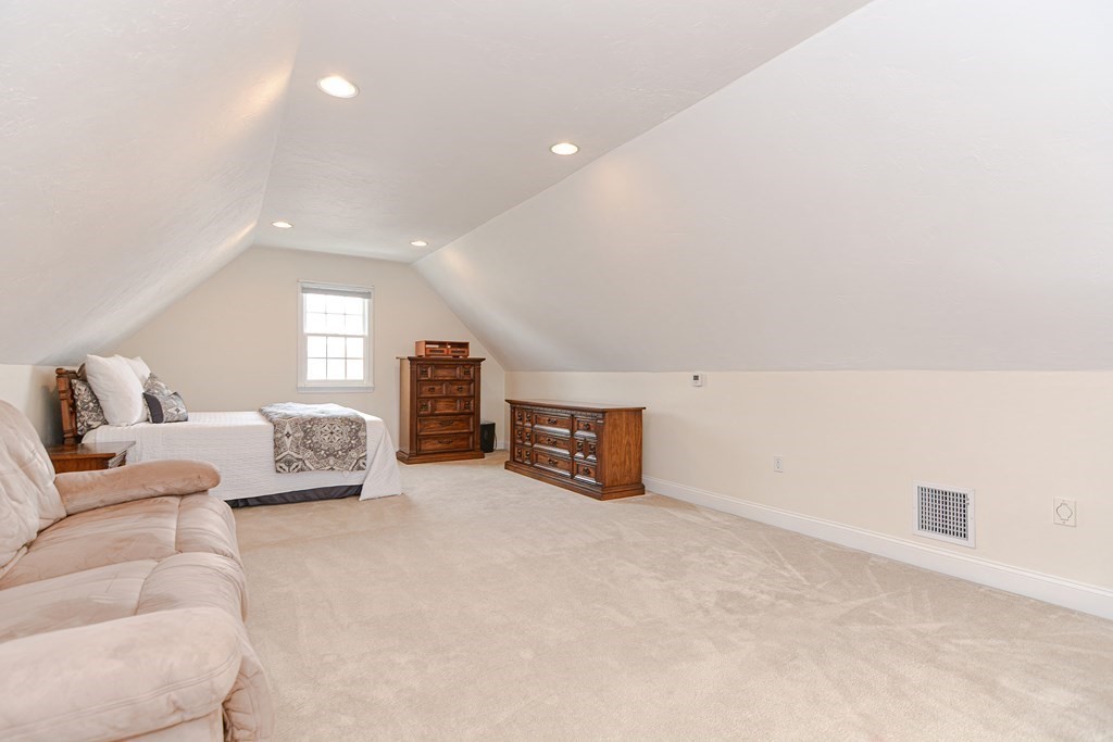 237 Pleasant Street, Unit 237 Norwood, MA 02062 - Photo 32 of 40 a spacious bedroom with a bed a couch and a window