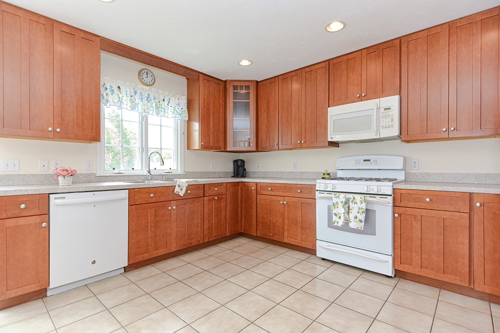 237 Pleasant Street, Unit 237 Norwood, MA 02062 - Photo 4 of 40 a kitchen with granite countertop sink cabinets and window