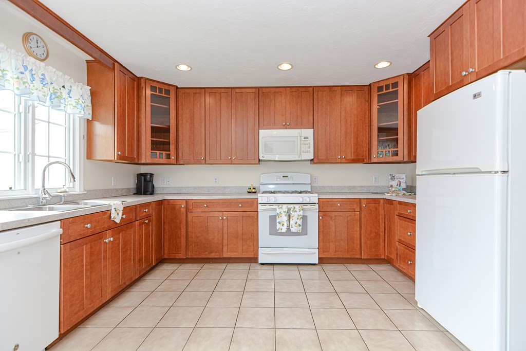 237 Pleasant Street, Unit 237 Norwood, MA 02062 - Photo 5 of 40 a kitchen with stainless steel appliances granite countertop a refrigerator sink and cabinets