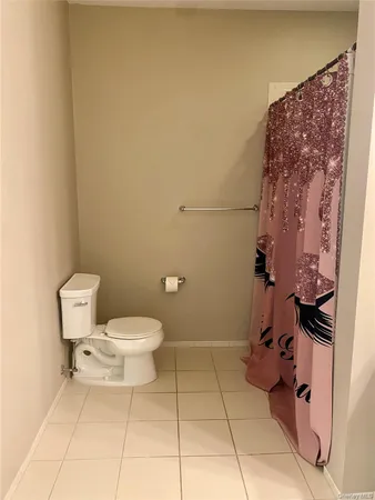 a bathroom with a toilet and a shower curtain