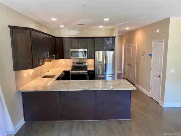 a large kitchen with stainless steel appliances a large counter top
