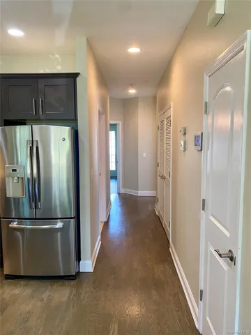 a view of a refrigerator in kitchen and wooden floor