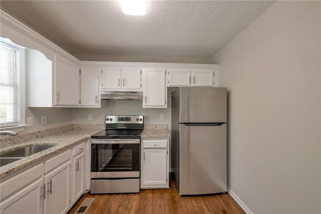 252 Amber Way Dallas, GA 30157 - Photo 12 of 40 a kitchen with a refrigerator stove and white cabinets