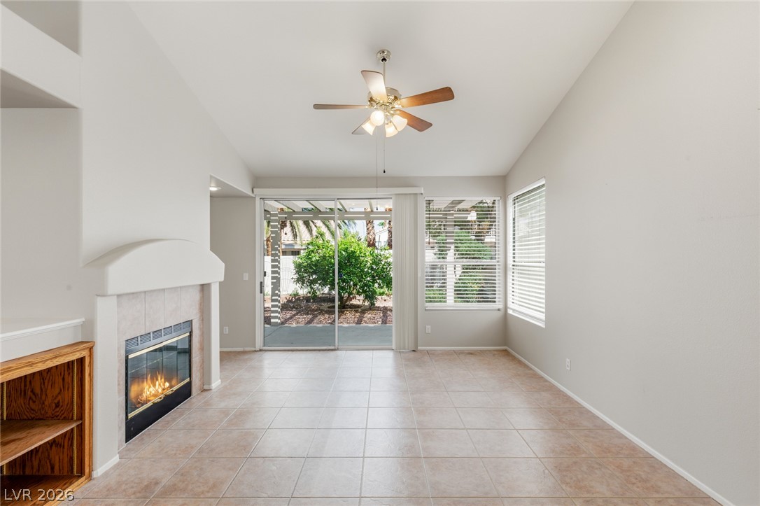 Tiled flooring and a fireplace anchor this living space beneath vaulted ceilings.