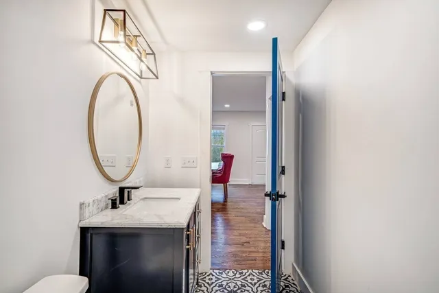 a bathroom with a sink a toilet and a mirror