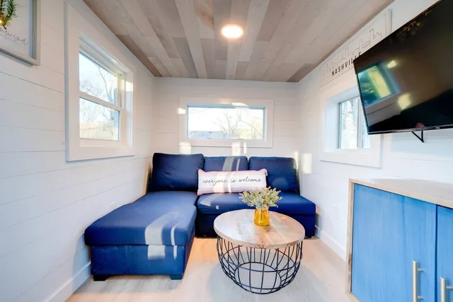 a living room with furniture a flat screen tv and a window