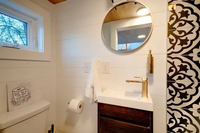 a bathroom with a sink mirror and toilet