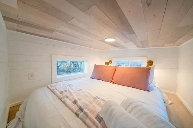 a bedroom with a bed and a painting on the wall