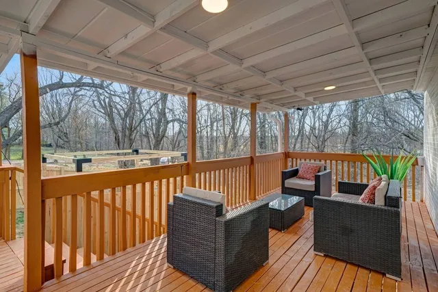 a balcony with wooden floor and outdoor seating