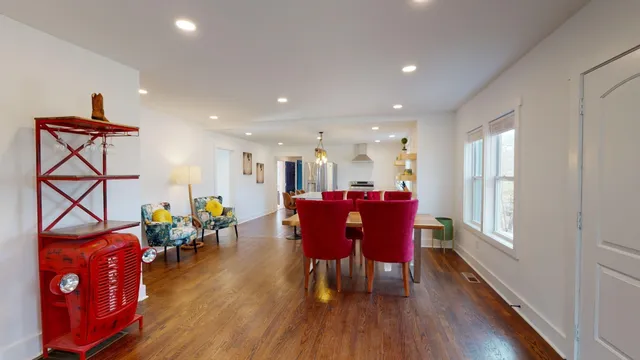 a dining room filled chandelier and wooden floor