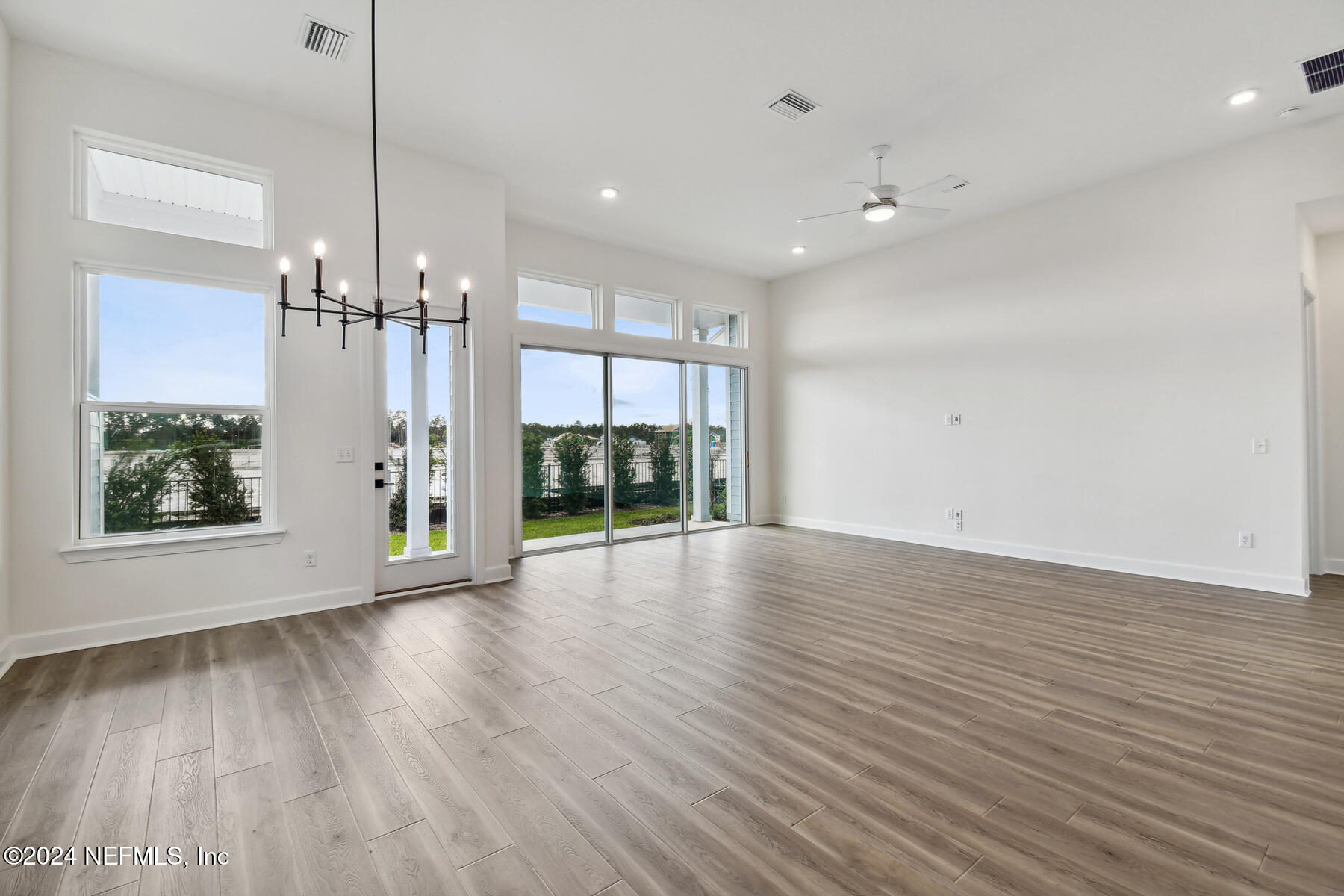 5608 Pathfinder Road Jacksonville, FL 32224 - Photo 12 of 36 a view of an empty room with wooden floor and a window