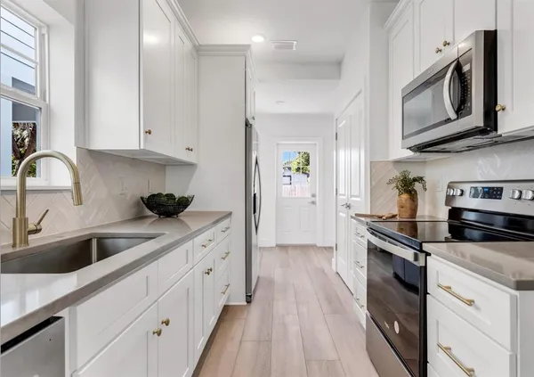 a kitchen with stainless steel appliances a sink a stove and microwave