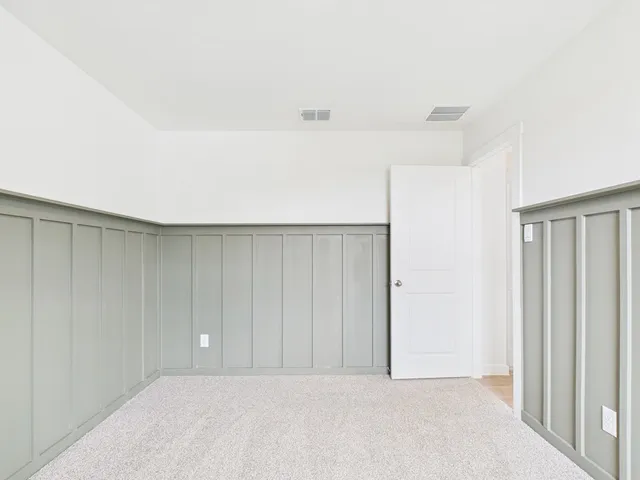 a view of a hallway with stainless steel appliances wooden floor and cabinet in a room