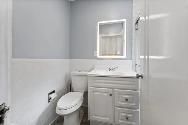 a bathroom with a granite countertop toilet sink and mirror