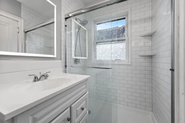 a bathroom with a sink a mirror and a shower