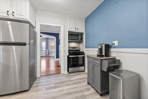 a kitchen with a refrigerator stove and wooden cabinets