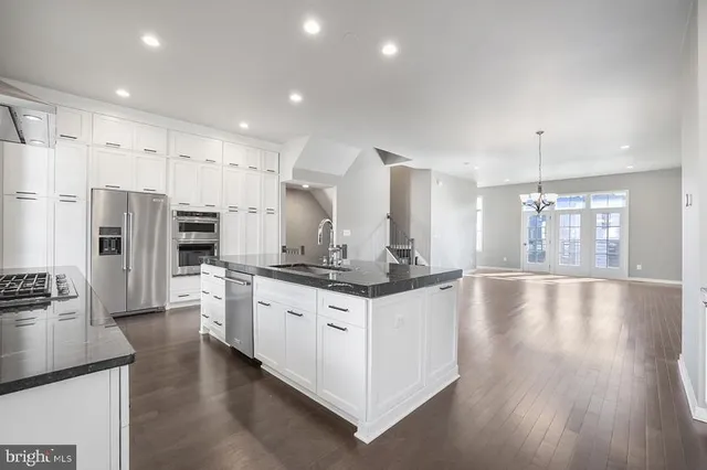 a kitchen with granite countertop a sink a stove and cabinets