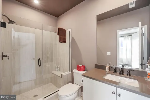 a large kitchen with stainless steel appliances granite countertop a stove a sink a refrigerator and white cabinets