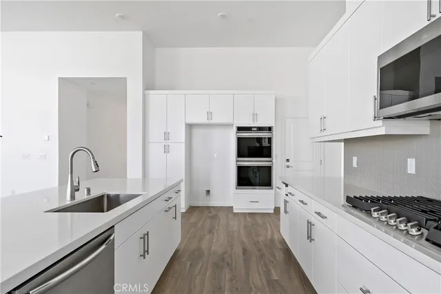 a kitchen with stainless steel appliances a sink stove and refrigerator
