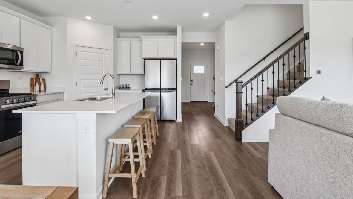 1871 Keating Drive Aurora, IL 60503 - Photo 9 of 27 a kitchen with stainless steel appliances kitchen island granite countertop a stove a sink a refrigerator and white cabinets with wooden floor