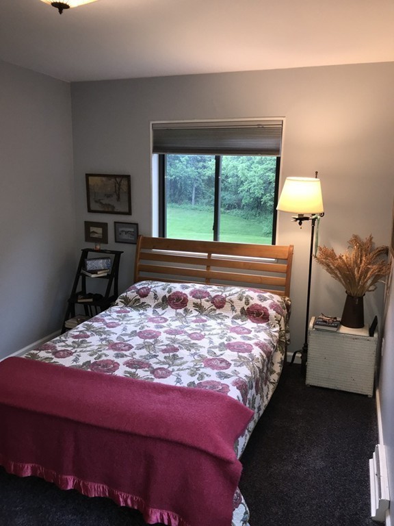 75 Spaulding Street, Unit 75 Amherst, MA 01002 - Photo 19 of 36 a bed sitting in a bedroom next to a window