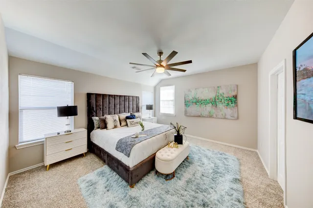 a bedroom with a large bed and a chandelier
