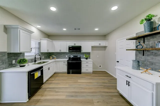a large kitchen with stainless steel appliances granite countertop a stove and a sink