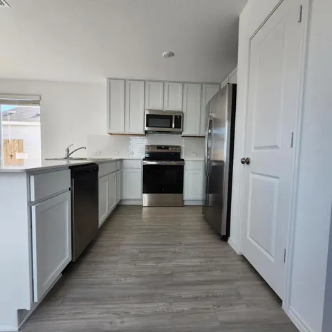a kitchen with stainless steel appliances kitchen island granite countertop a stove and a refrigerator