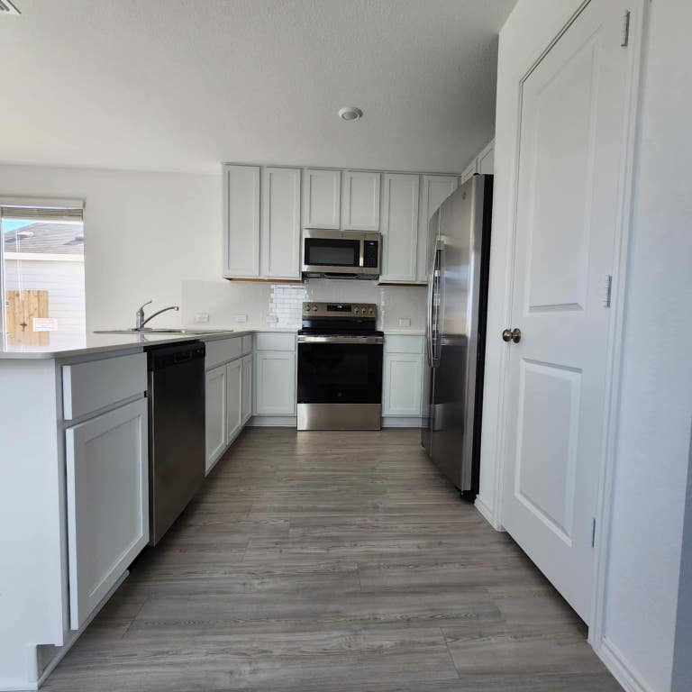 543 Commander Abbott Drive Jarrell, TX 76537 - Photo 4 of 12 a kitchen with stainless steel appliances kitchen island granite countertop a stove and a refrigerator