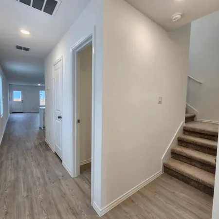 a view of a hallway with wooden floor and entryway