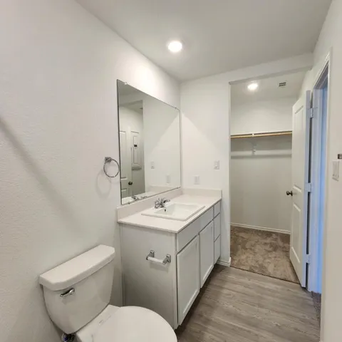 a bathroom with a toilet sink and mirror
