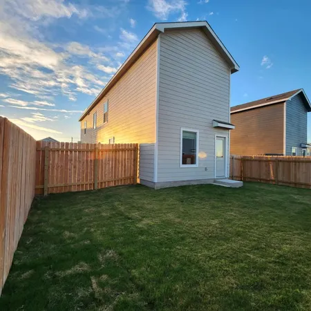 a view of a backyard with wooden fence