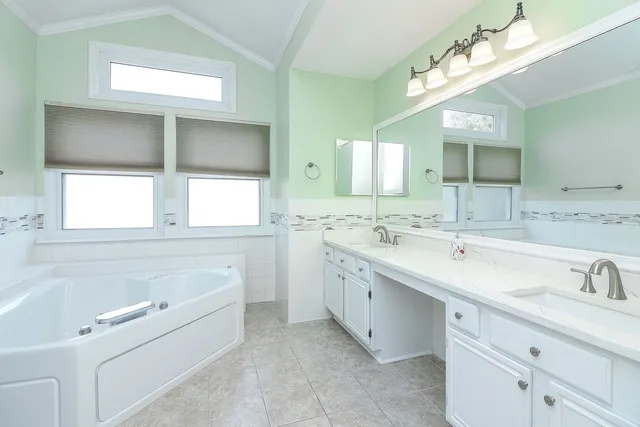 a bathroom with a sink double vanity mirror and a bathtub