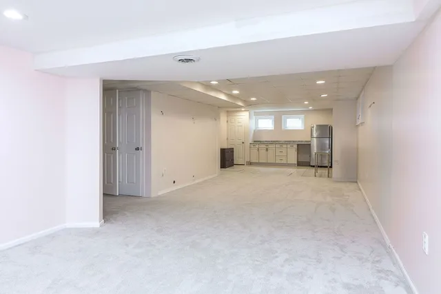 an empty room with a cabinet and mirrors