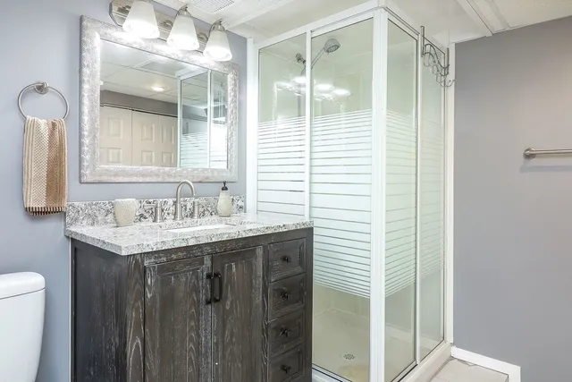 a bathroom with a granite countertop sink and a mirror