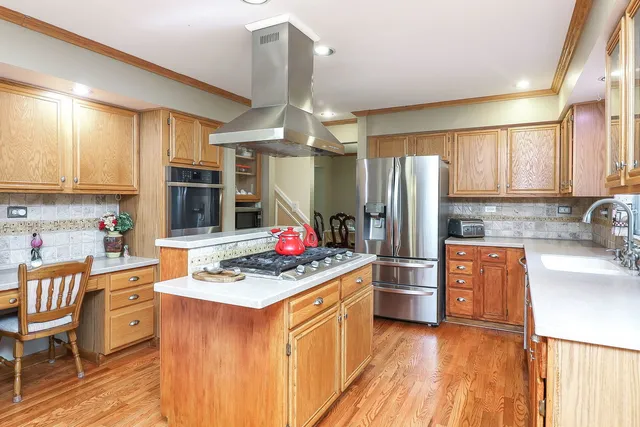 a kitchen with stainless steel appliances granite countertop a stove refrigerator and a sink