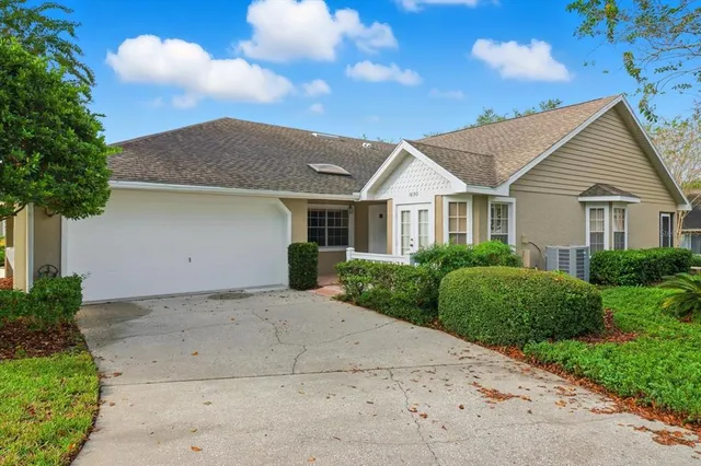 a view of a house with a yard and potted plants