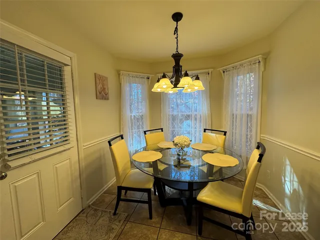 a view of a dining room with furniture and chandelier