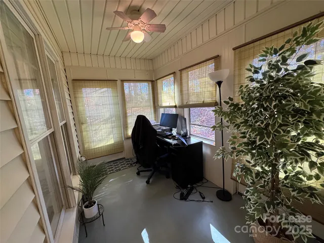 a view of a workspace with furniture and a window