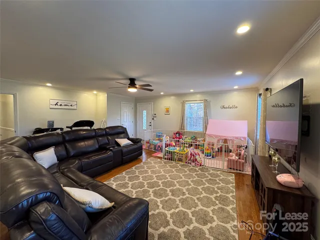 a living room with furniture a flat screen tv and a coffee table
