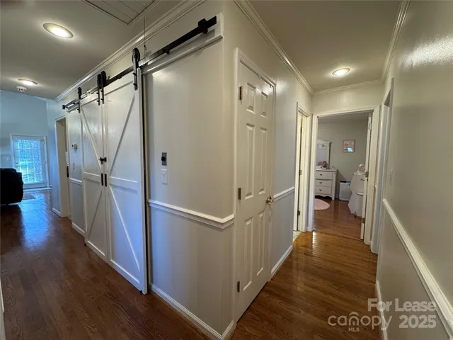a view of a hallway with wooden floor and staircase