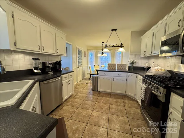 a kitchen with a stove a sink and a microwave