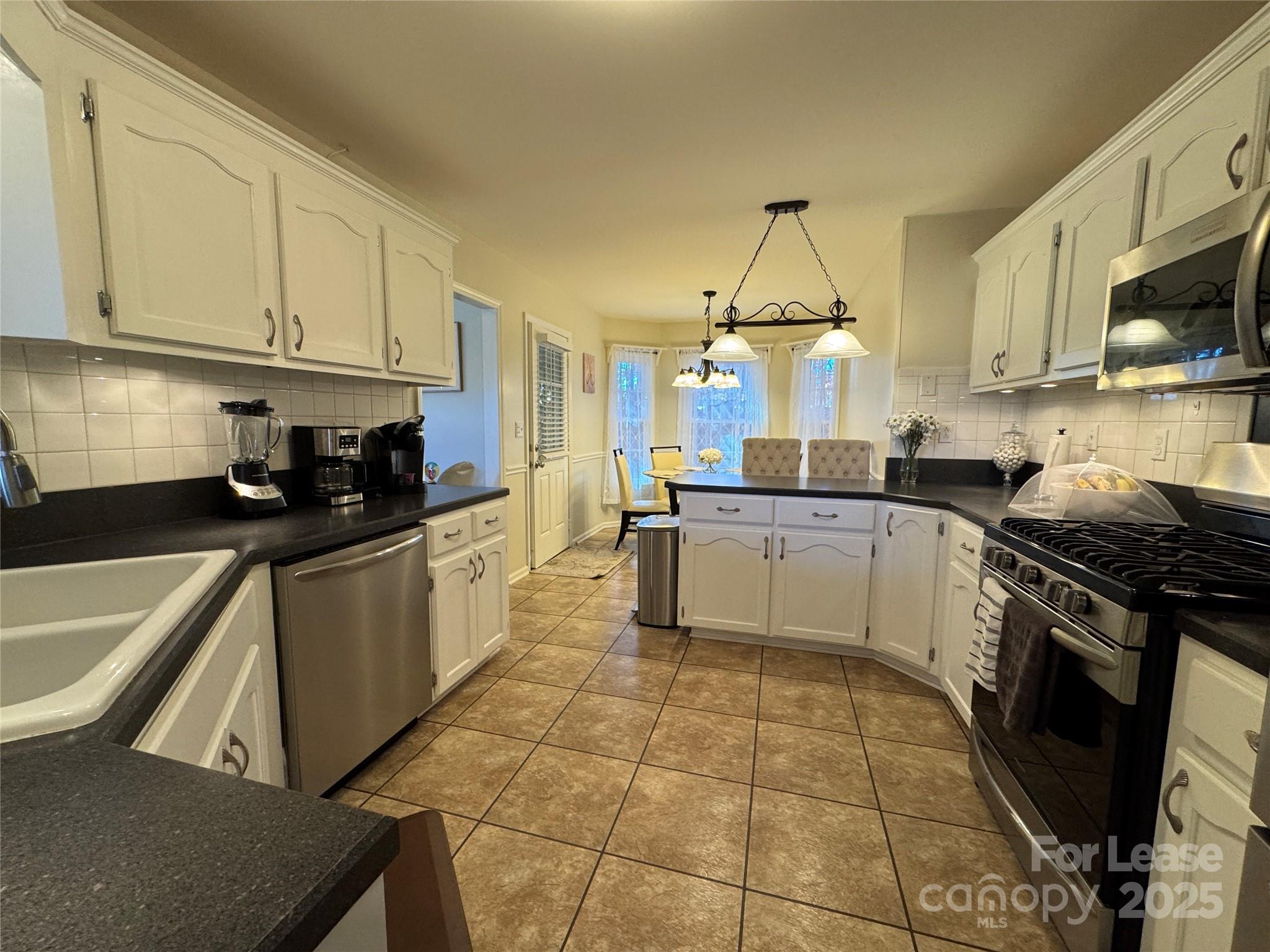 132 General Pemberton Street Mount Holly, NC 28120 - Photo 9 of 21 a kitchen with a stove a sink and a microwave