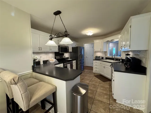 a kitchen with stainless steel appliances granite countertop a sink a stove and a refrigerator