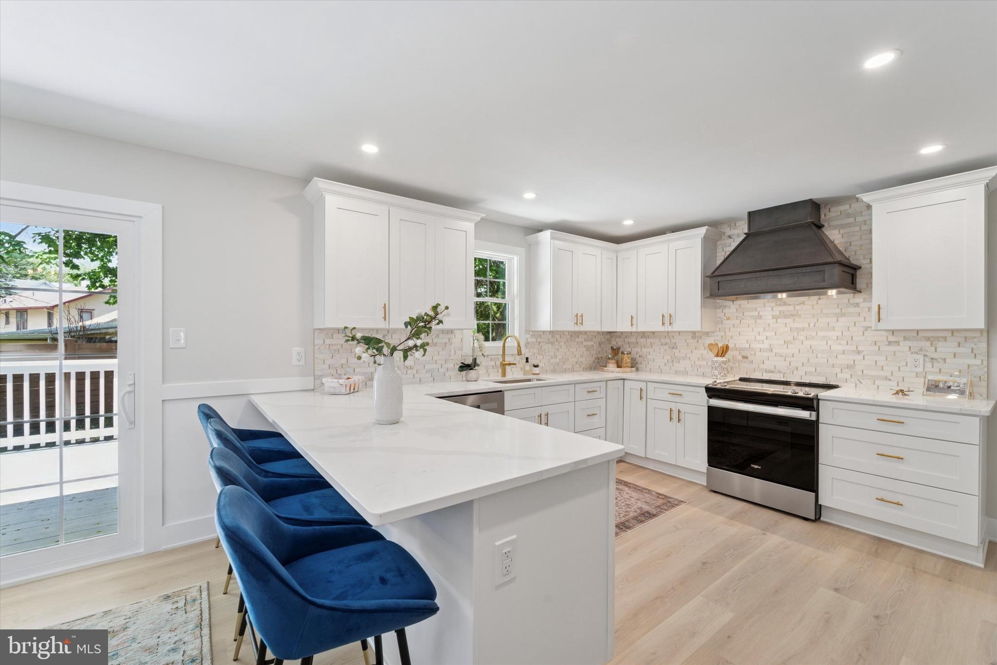 130 Walnut Avenue Pitman, NJ 08071 - Photo 9 of 35 a kitchen with stainless steel appliances kitchen island granite countertop a sink dishwasher a stove a refrigerator and a dining table with wooden floor