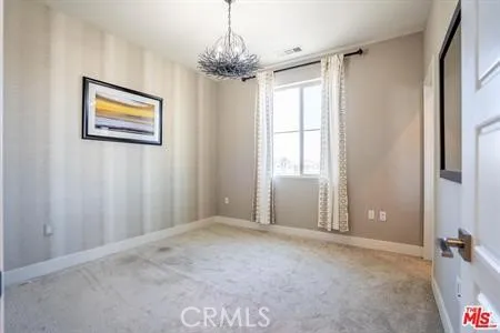 a view of a livingroom with a chandelier fan and windows