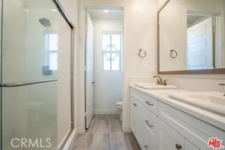 a bathroom with a granite countertop sink mirror and a shower